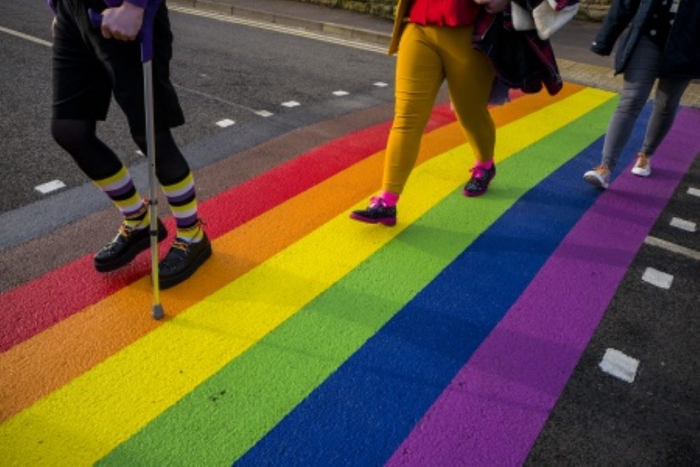 Students walking across a rainbow crossing