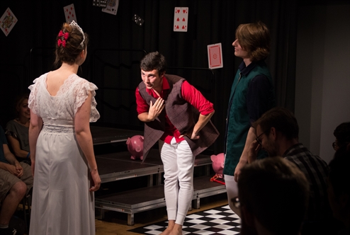 A still shot from a Russian play. A male actor is bowing toward a female actor wearing a white dress.