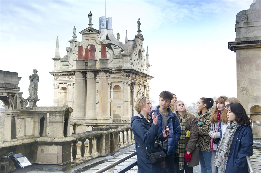 Group of students on roof of Wollaton Hall exploring architecture