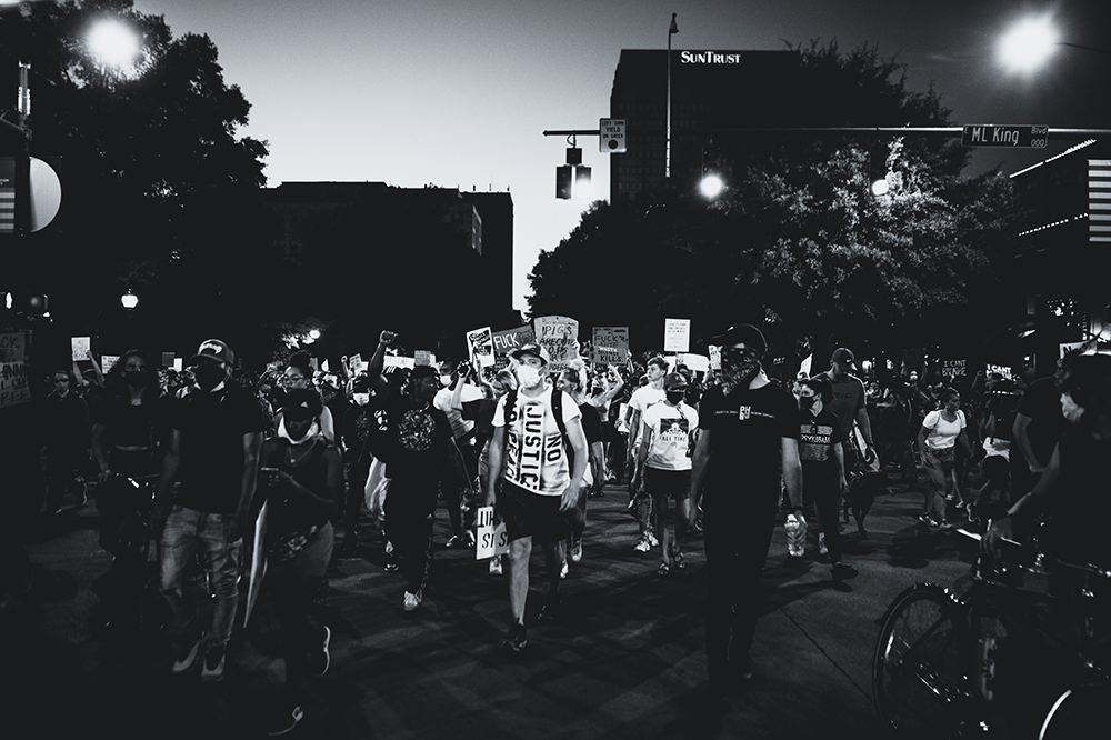 A black and white image of a protest by night