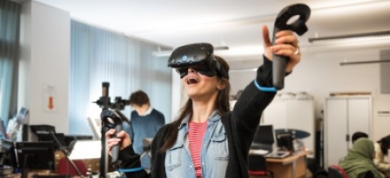 Virtual reality experience for one student with headset and hands in the air