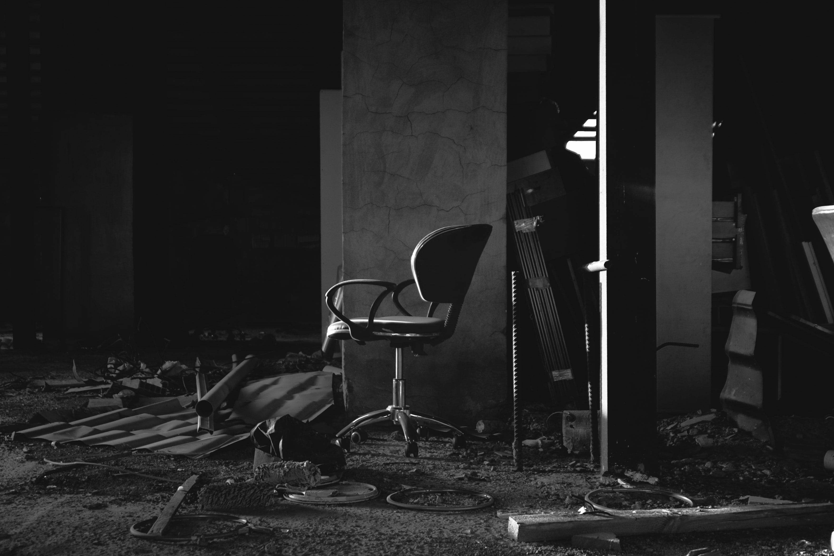 black and white photo of an office chair in a derelict and abandoned building