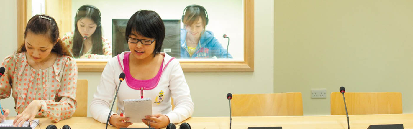 Four students using translation booths