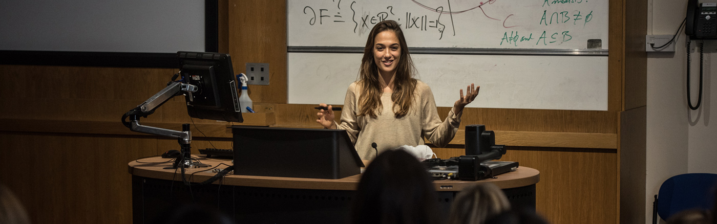 Lecturer in front of class explaining things