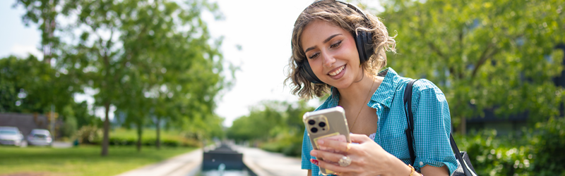 Student looking at a mobile phone and smiling