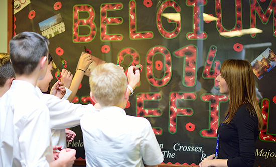 students working on a poster with teacher