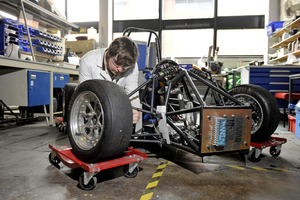 Student working on a car in a workshop