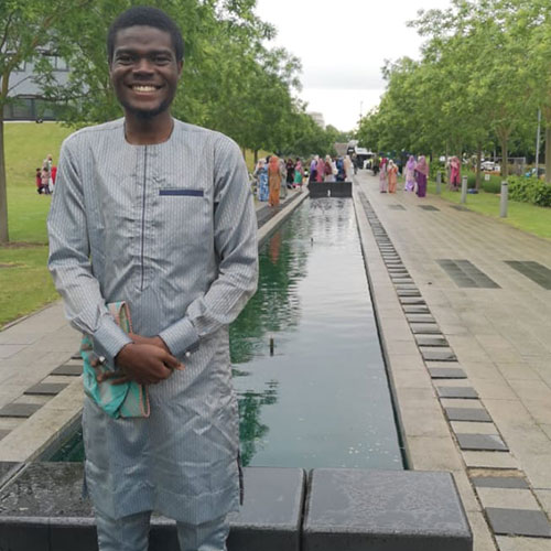 Abdullah Okunola stood in front of a river at a park