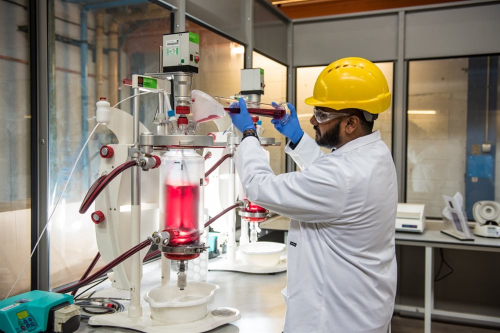 A male postgraduate working in a chemical engineering laboratory