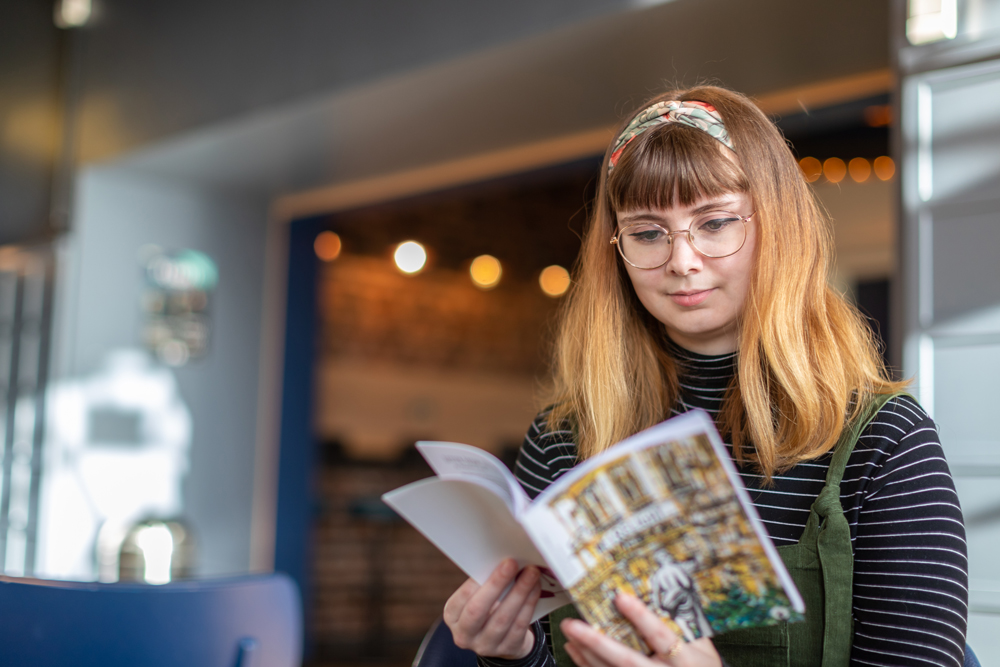 A student reading Firelight magazine in Portland Cafe