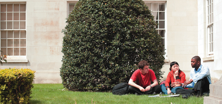 Three students sat outside Trent Building,