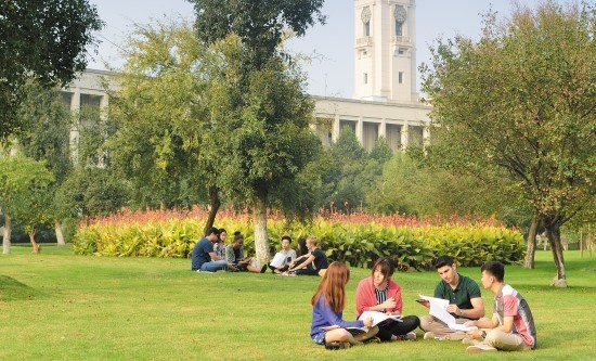 Group of undergraduate and postgraduate students studying and talking opposite the Trent Building, Ningbo Campus, China