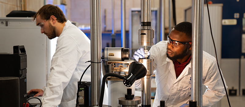 student and techician using Instron 8801 load frame