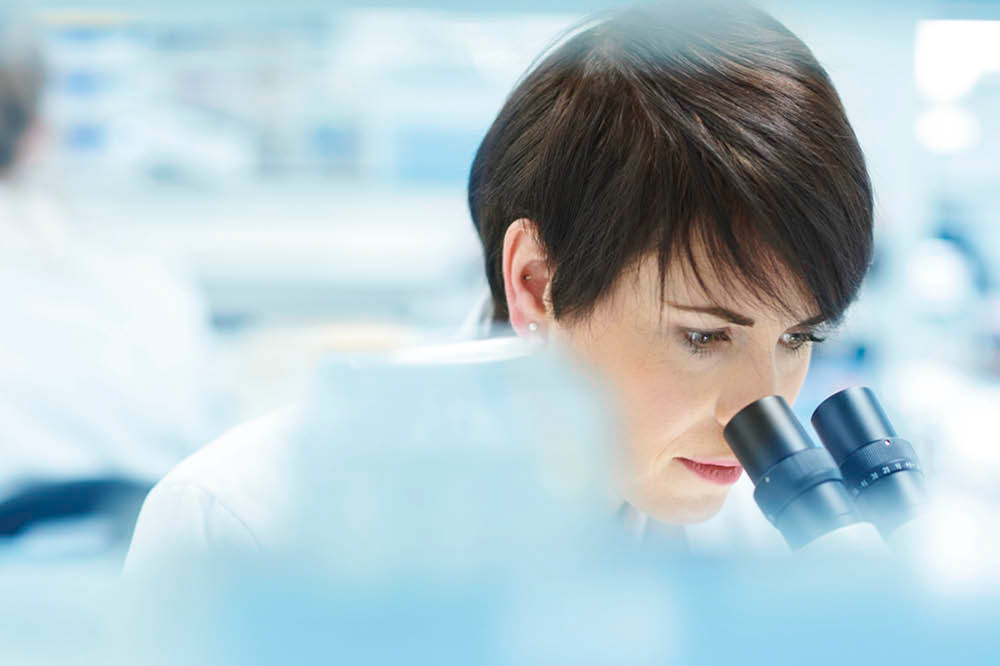 woman looking in microscope