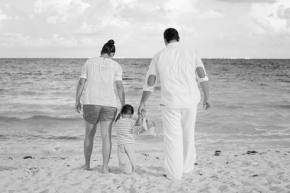 Mother and father walking with a toddler on a beach