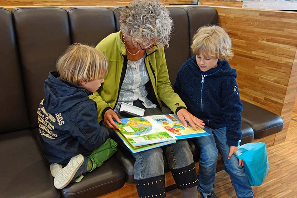 Older lady reading to two children