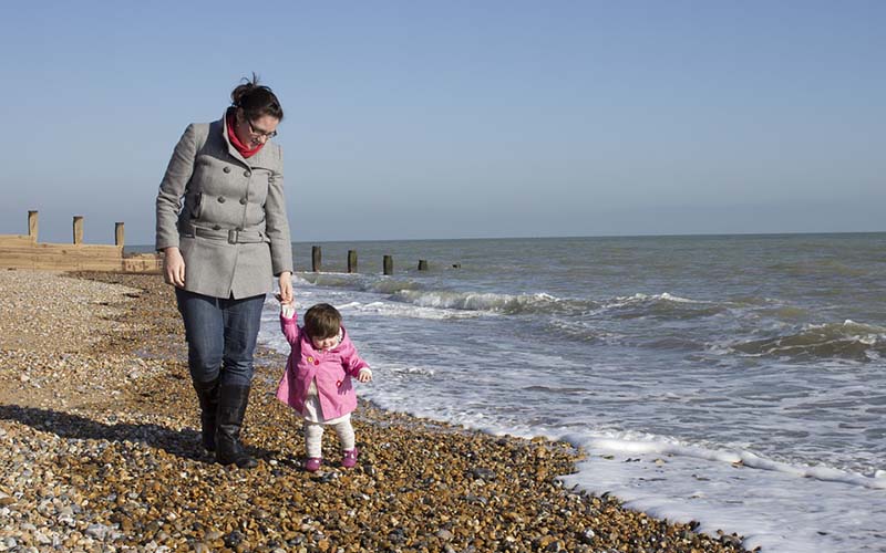 A parent helping a child walk