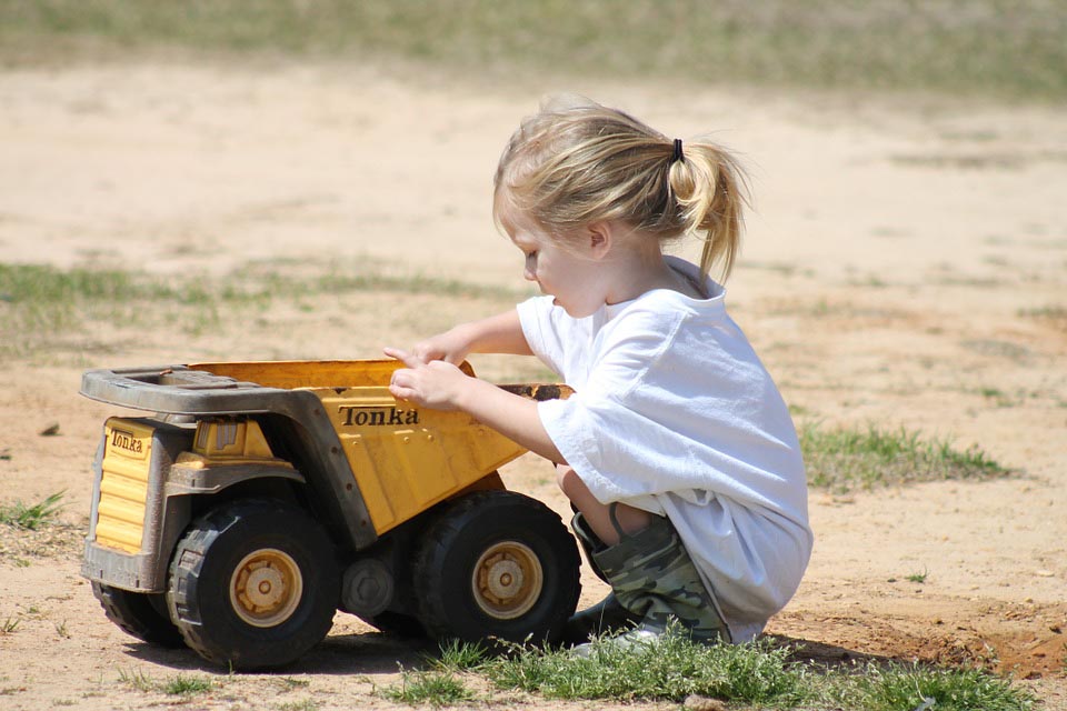 child playing with toy dumper truck