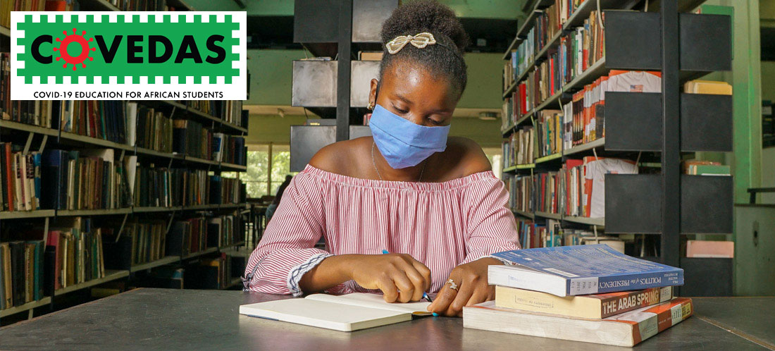 African student wearing mask and working in library