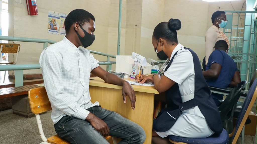 Male patient with nurse preparing for vaccination.