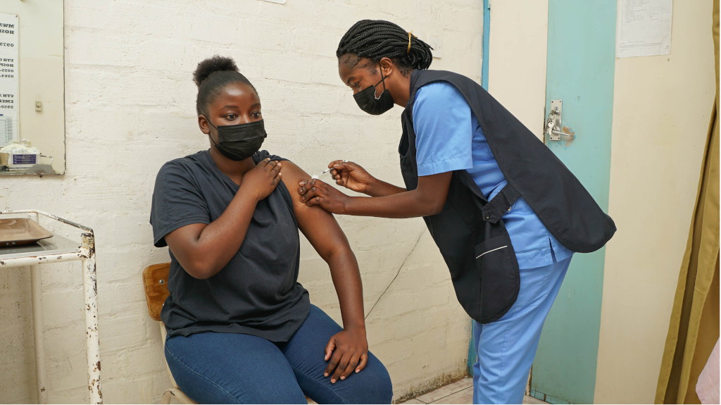 Female patient preparing for vaccination injection from nurse.