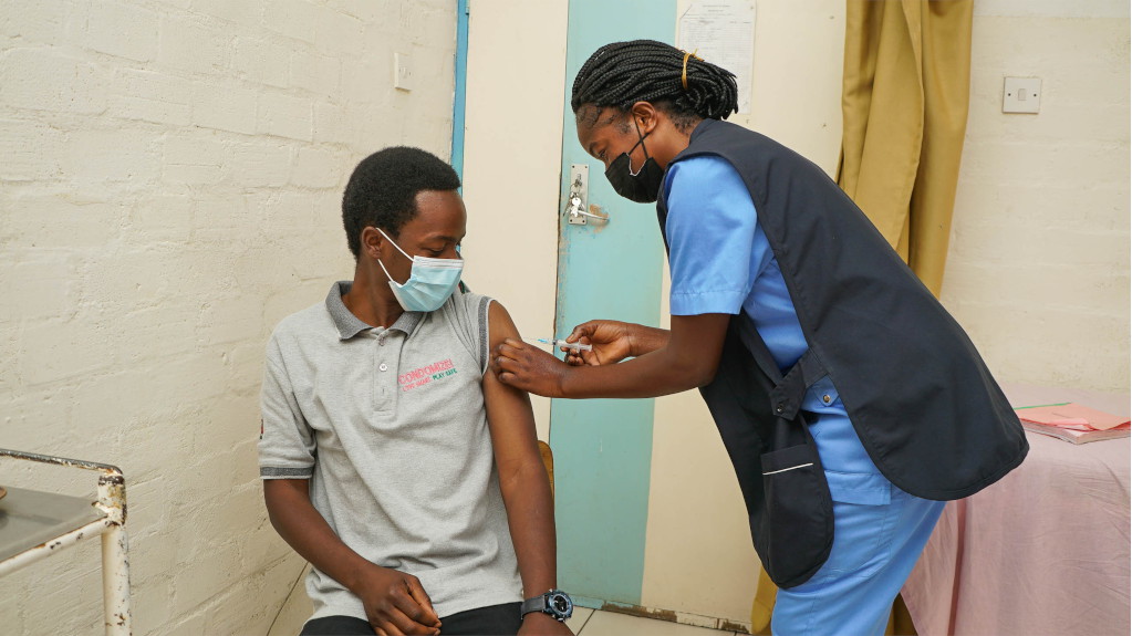 Male patient preparing for vaccination injection from nurse.