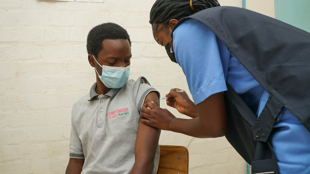 Male patient receiving vaccination injection from nurse.