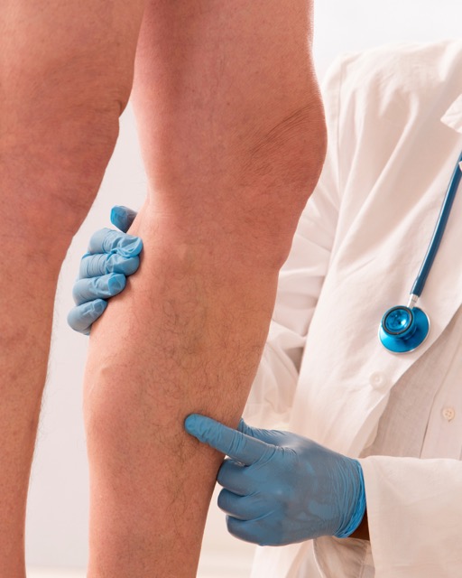 A patient having their knee examined in clinic