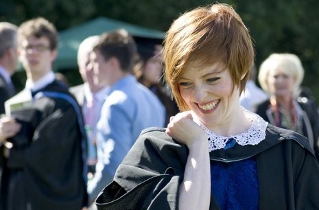 Person in a graduate gown laughing