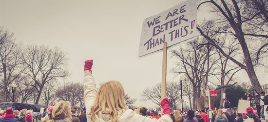 Group of people demonstrating and holding up placards