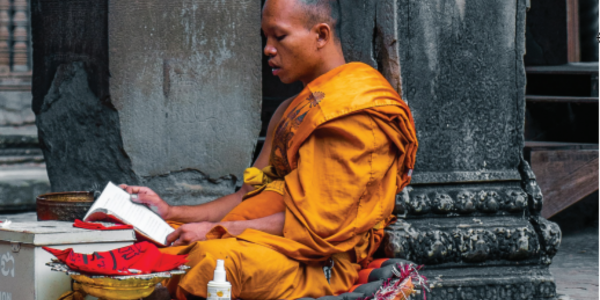 A buddhist man reading a book