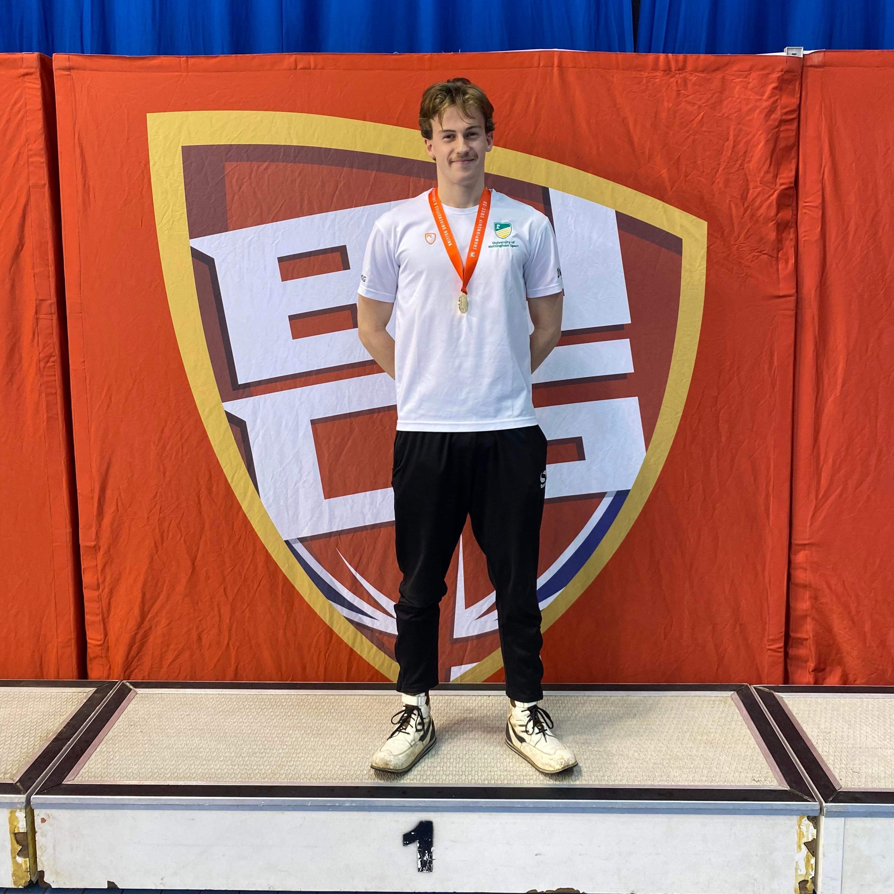Owen stands on a swimmers' winners podium