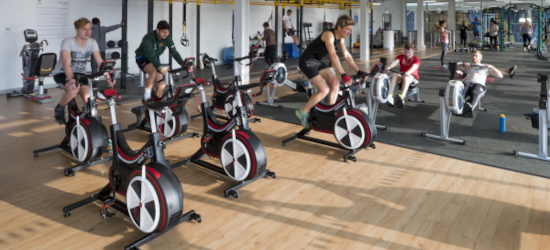 Student using fitness suite including exercise bikes and rowing machines