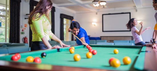 Students playing pool in residential hall common room
