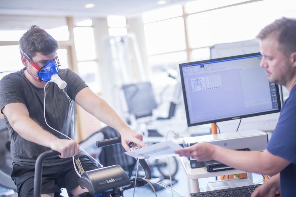 Academic conducting research with participant on a bike