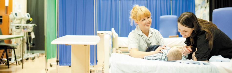 Female midwifery student assessing a new born baby, Nursery and Midwifery Unit, QMC