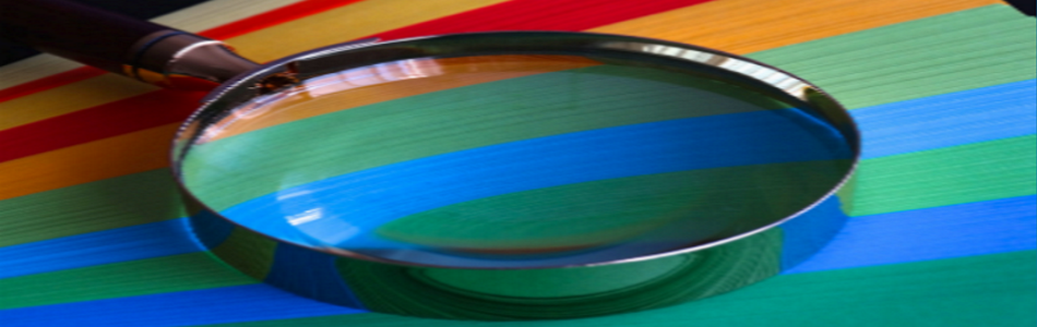 Close up of magnifying glass on coloured paper