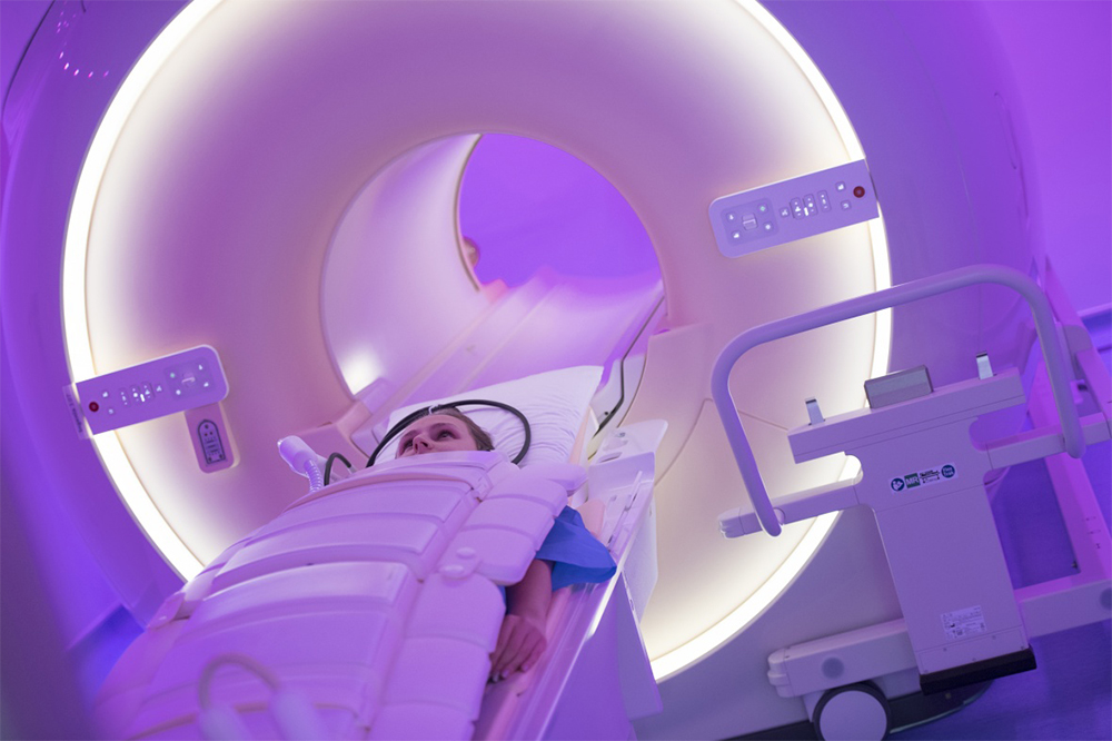 A person being slid into the circular hole of an MRI machine