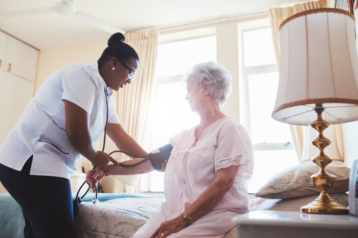 Nurse testing the blood pressure on an elderly patient