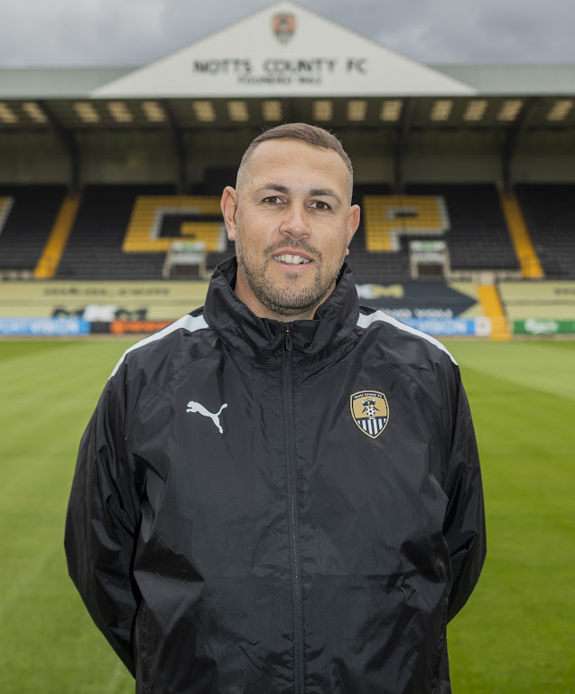Head and shoulders portrait of Gavin Mee standing on Meadow Lane pitch