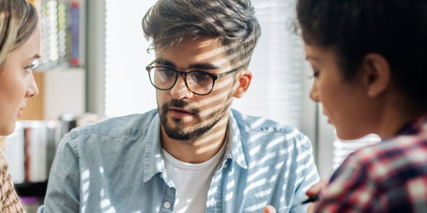 Three students talking, looking serious
