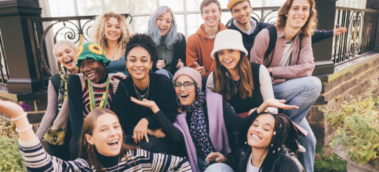 Mixed group of students smiling and laughing at the camera