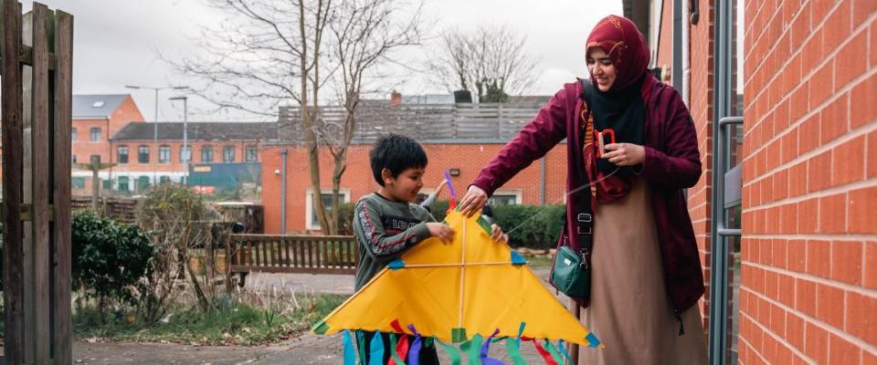 Young boy and woman holding a yellow kite 