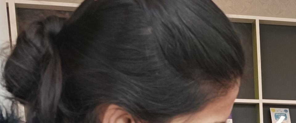 Woman wearing a bright pink coat talking to a mother and daughter