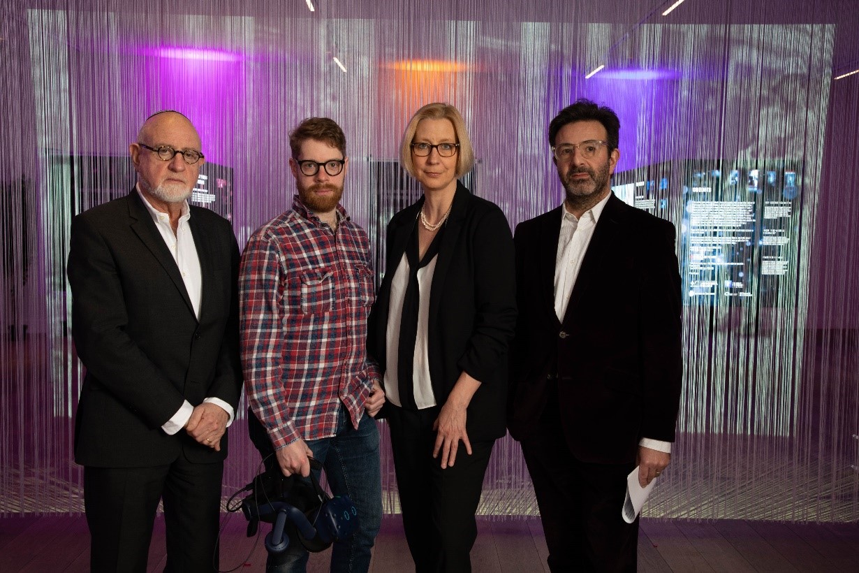 Four people pose at the opening of “The Eye as Witness”; L-R: Henry Grunwald, Chair of Trustees of NHCM (National Holocaust Centre and Museum), Paul Tennent (Mixed Reality Lab Nottingham), Maiken Umbach, and Marc Cave (CEO of NHCM).