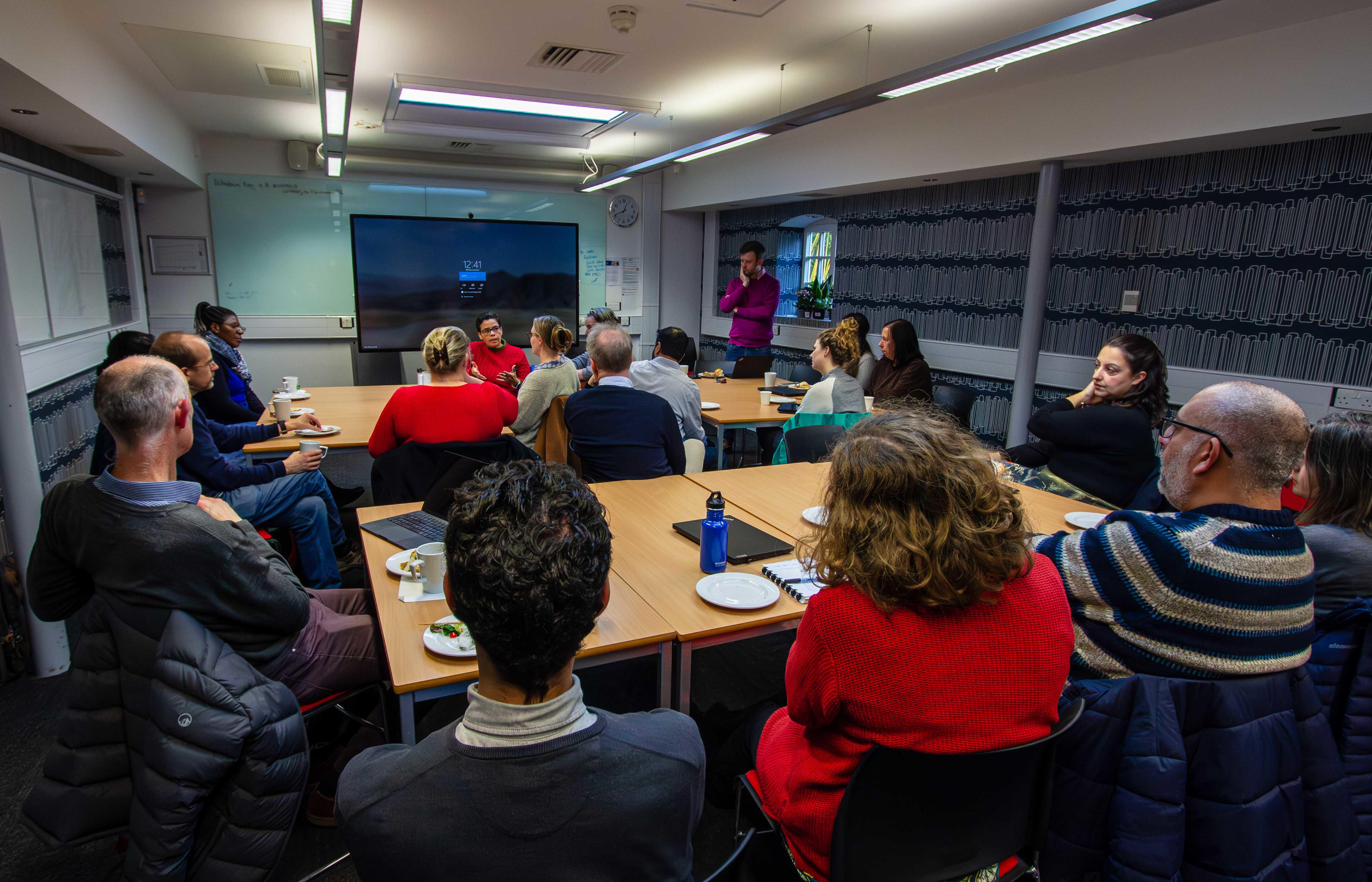 A group of people sitting around two tables.