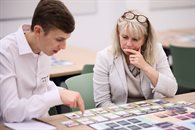 A man and a woman looking at a board game spread on the table