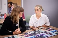 Two white women having a discussion in a room with a board game on the table