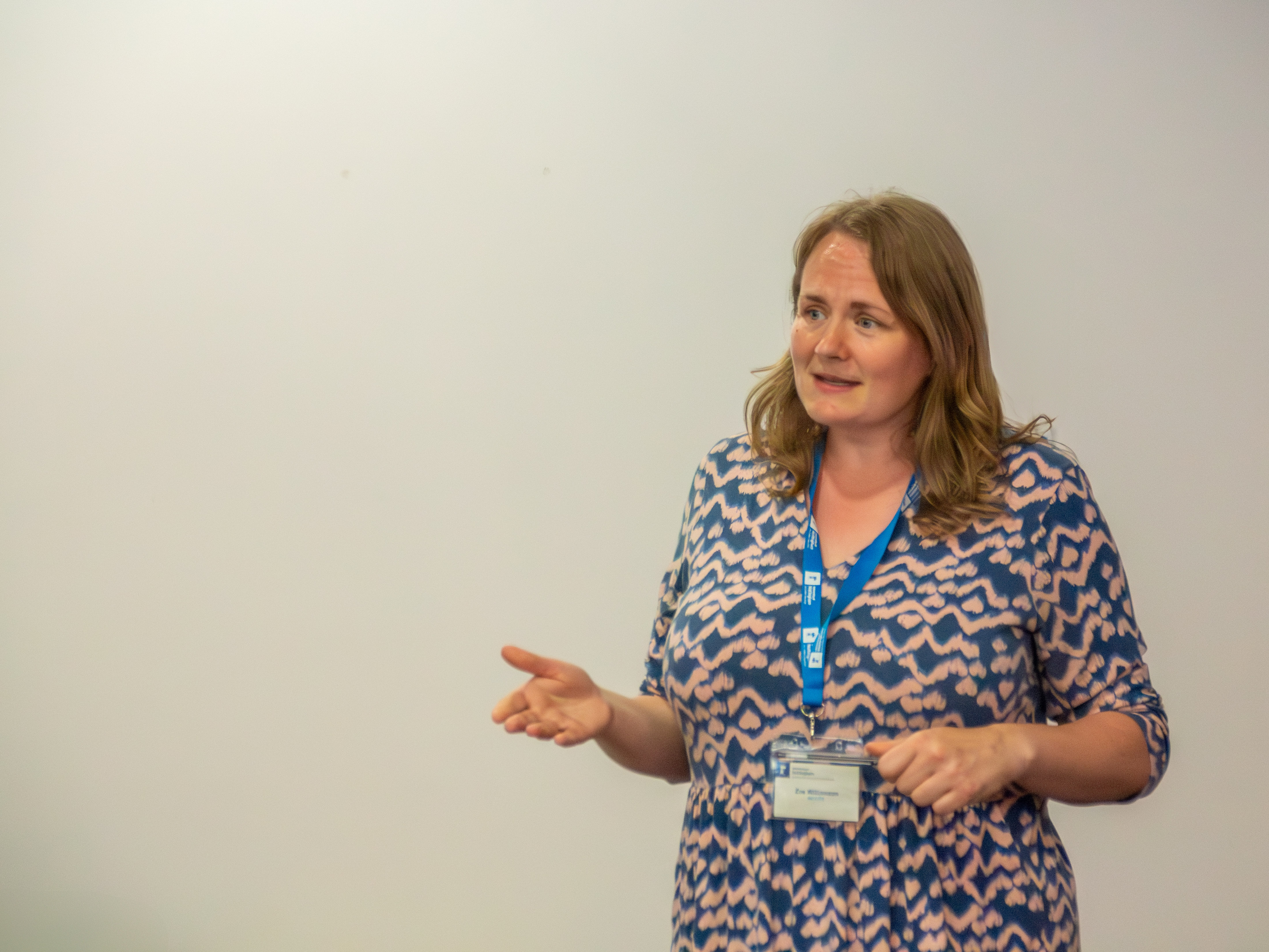 Woman talking in front of a plain white background