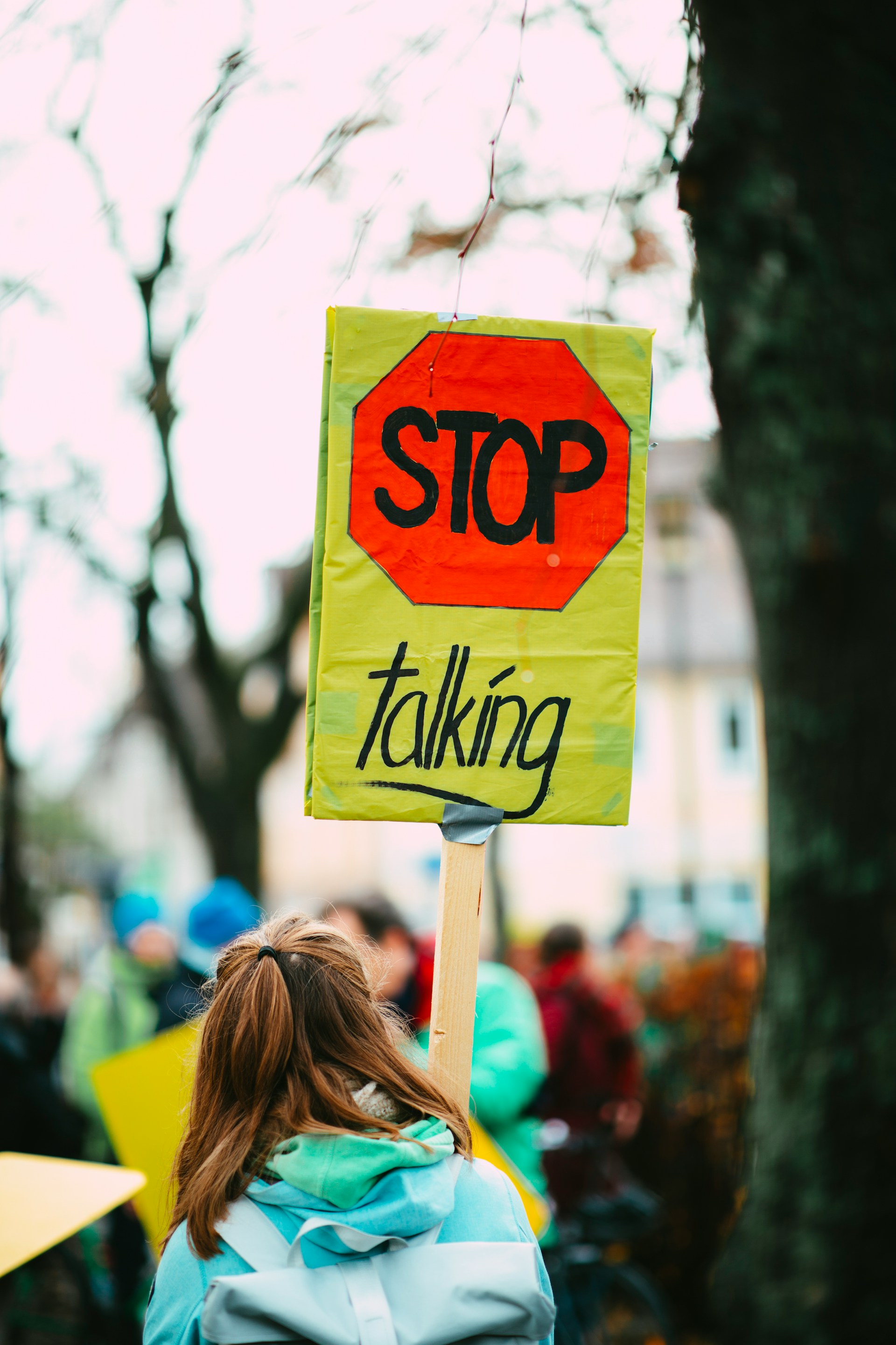 Girl holds sign that says 'Stop Talking' at climate march